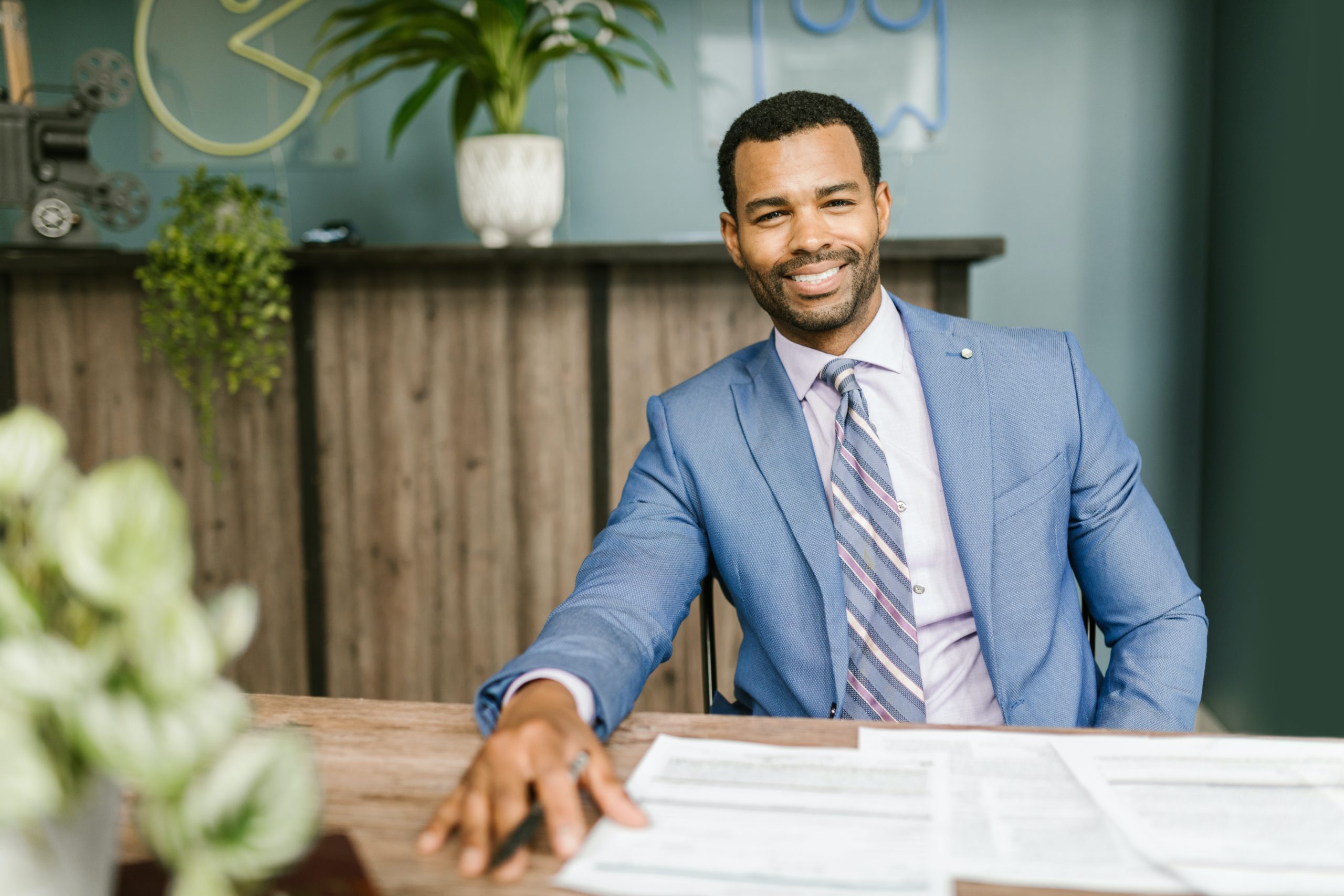 male accountant smiling sitting at desk with paperwork